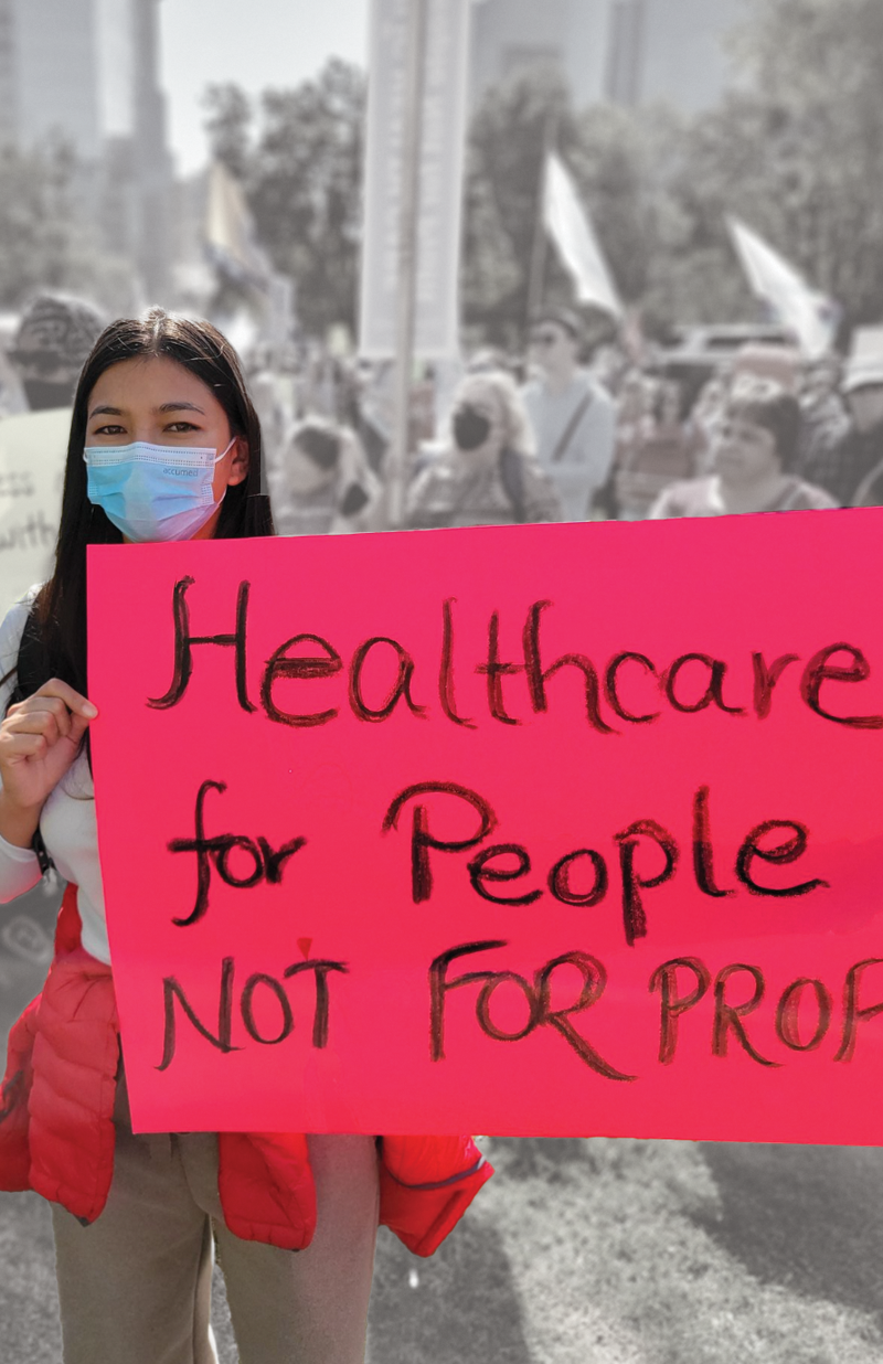 Woman holding sign that says "Healthcare for people NOT for profit" at a protest