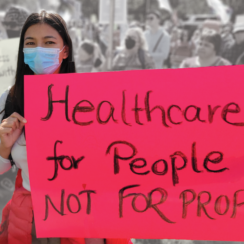 Woman holding sign that says "Healthcare for people NOT for profit" at a protest